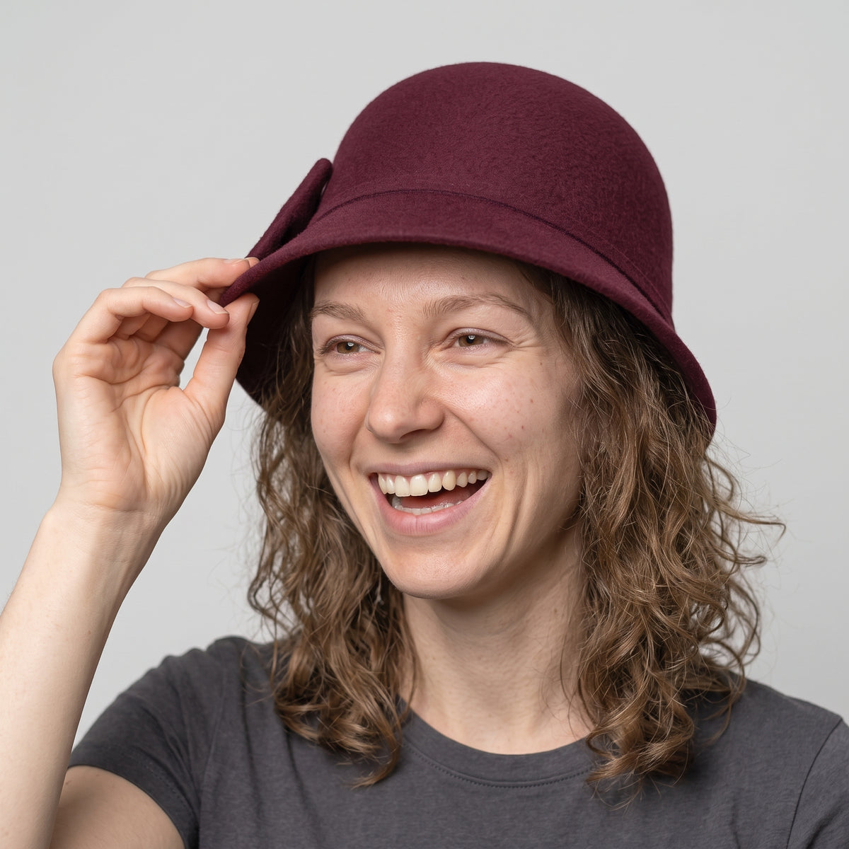 Hoed Wit - model wearing wine red hat, action pose